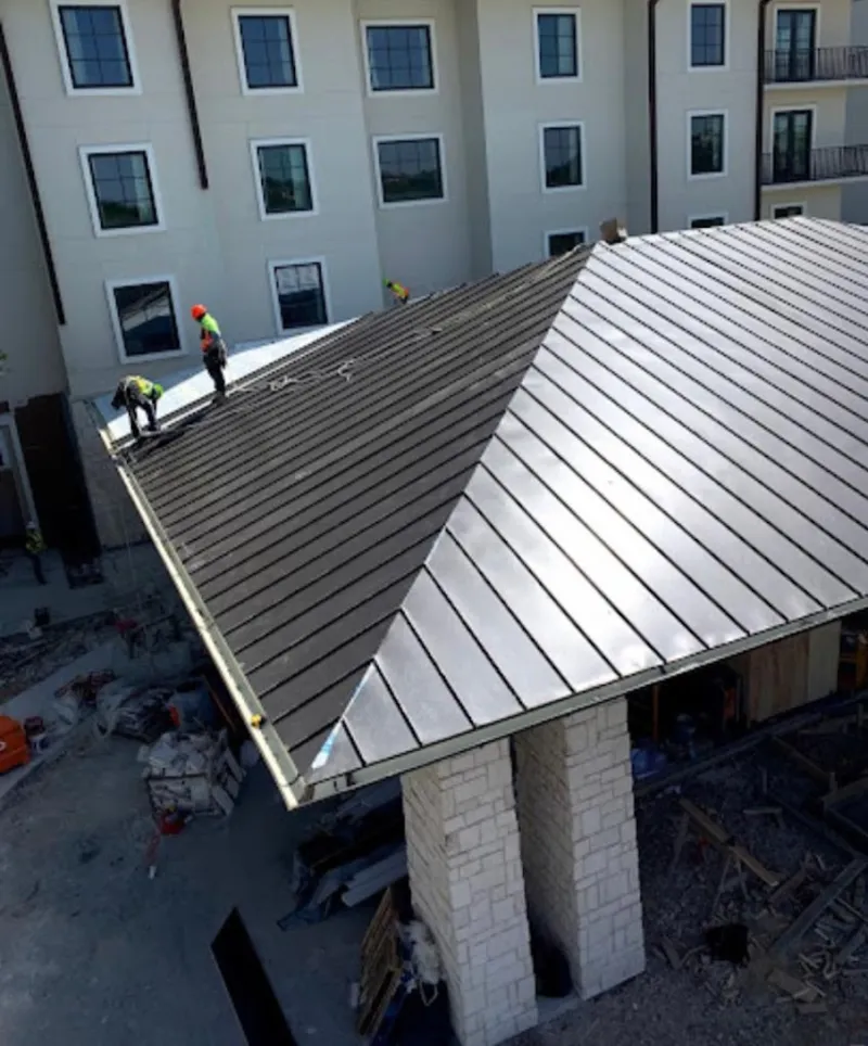 Crew installing standing seam metal roof panels on a commercial project in Pottstown